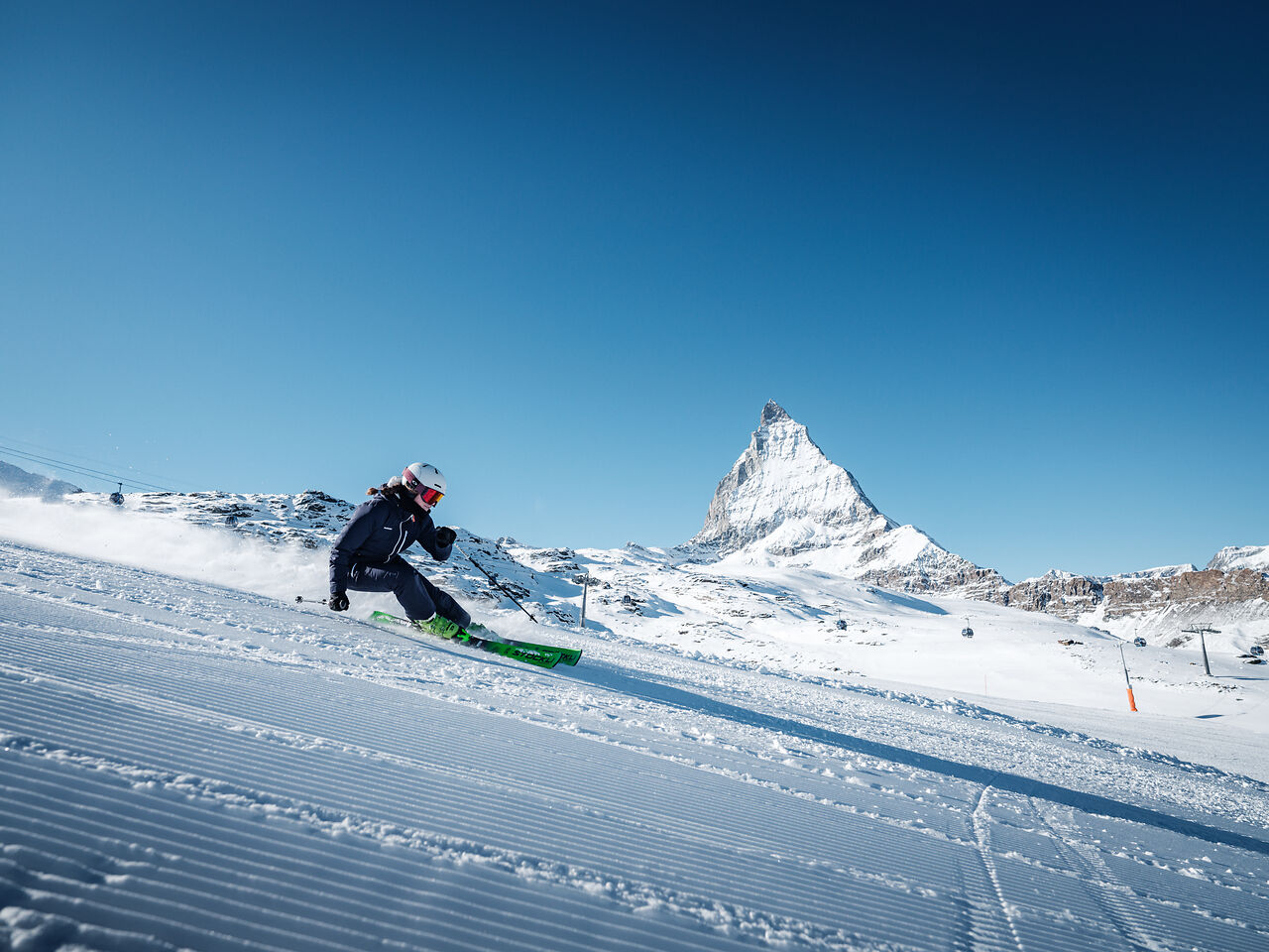 Skifahrende auf der Piste mit Blick auf das Matterhorn in Zermatt