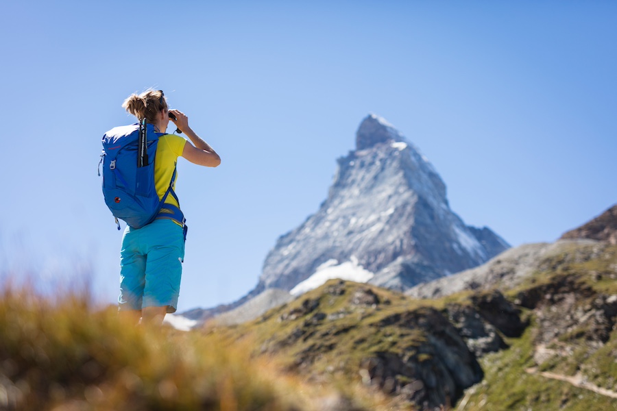 Eine Wanderin begutachtet das Matterhorn mit einem Feldstecher
