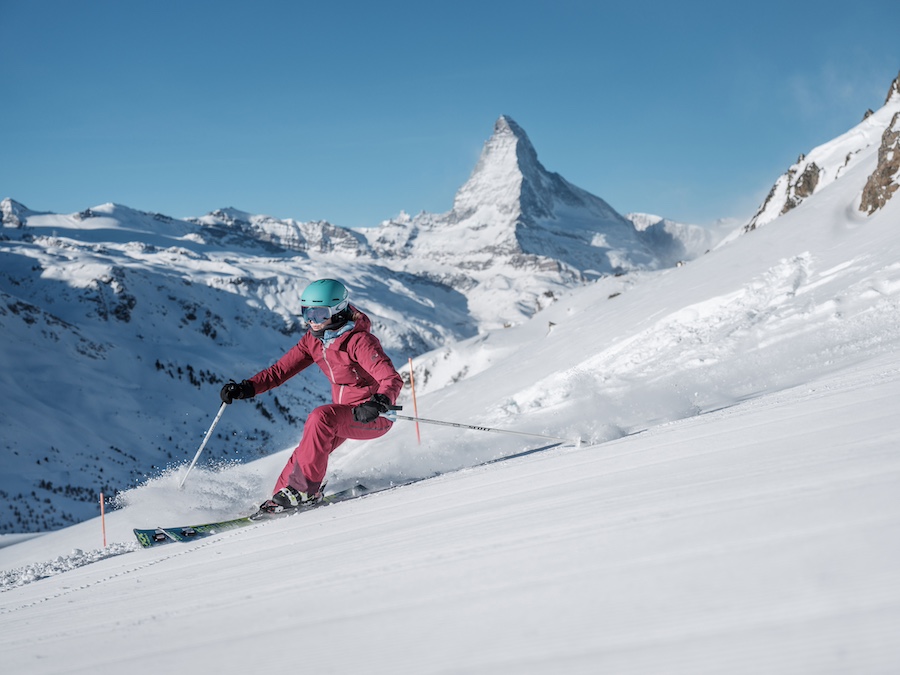 Eine Skifahrerin auf einer Piste oberhalb von Zermatt